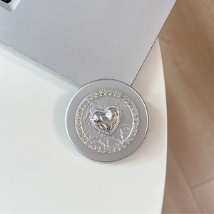 Detail of silver magnetic phone grip featuring a crystal heart and rhinestone border