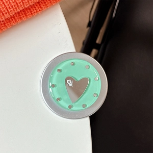 Close-up of mint green round phone grip with silver heart and mine text engraving