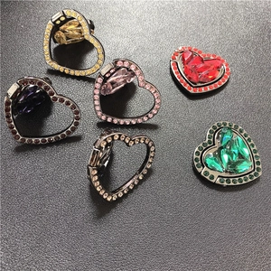 Detail showing various colors of heart-shaped phone ring holders with sparkling crystals