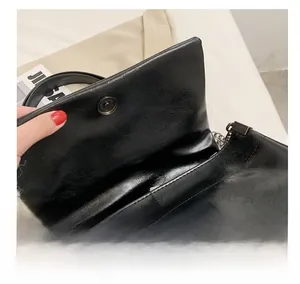 Detail showing the strong magnetic closure and oil-wax leather texture of the handbag