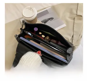 Internal layout of black chain bag with zipper compartments for cosmetics and phone