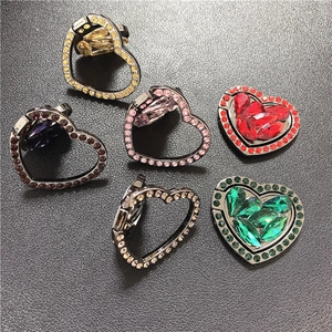 Heart-shaped crystal phone ring holder with rhinestones in multiple colors shown on dark background