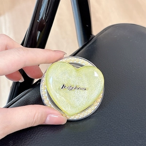 Macro shot of heart-shaped MagSafe phone grip with glitter, pearls, and Luckyhorse logo
