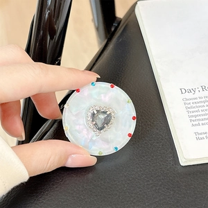 Detail of magnetic heart rhinestone phone grip with iridescent pearl finish and colorful dots
