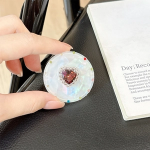 Macro detail of magnetic telescopic phone stand with red heart gem and colorful rhinestones