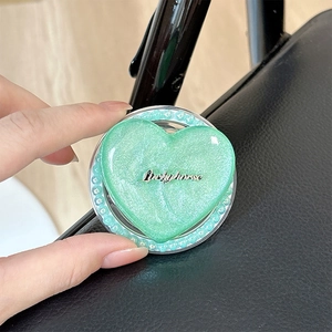 Detail of light green heart MagSafe phone grip with Luckyhorse metal logo and pearl trim