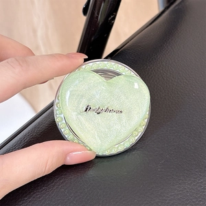 Detail of green glitter heart phone socket with Luckyhorse text and pearl trim