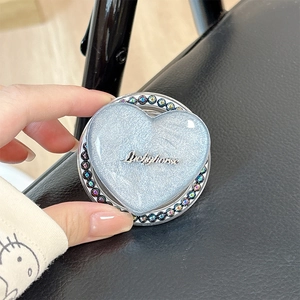 Close-up of heart-shaped magnetic phone grip with blue glitter and rhinestone edges