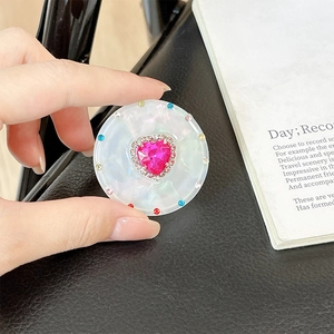 Detail of magnetic telescopic phone stand with pink heart gemstone and colorful rhinestones