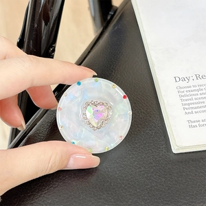 Detail of magnetic heart rhinestone phone grip with colorful gems and pearlescent base