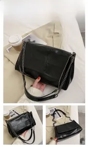 Detail of black soft PU leather shoulder bag with square stitching and metal chain strap