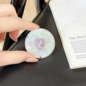 Close-up of magnetic phone grip with heart-shaped purple gem and colorful rhinestones