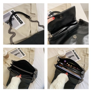 Detail view of black textured PU leather crossbody bag with magnetic closure and compartments