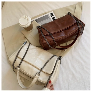 Flat lay of soft PU leather tote bags in dark brown and cream white with quilted stitching