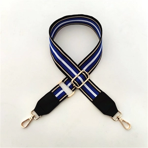 Detail of adjustable wide striped shoulder strap with gold metal hooks and leather ends