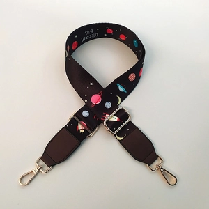Detail of adjustable wide nylon bag strap featuring space planets and Dream BIG slogan