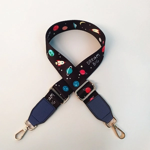 Macro detail of adjustable planet print shoulder strap with gold metal lobster clasps
