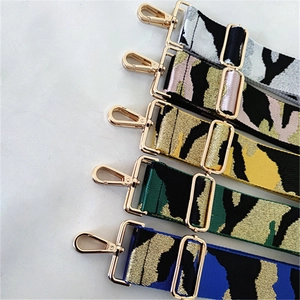 Close-up of colorful camouflage jacquard bag straps with golden metal swivel hooks