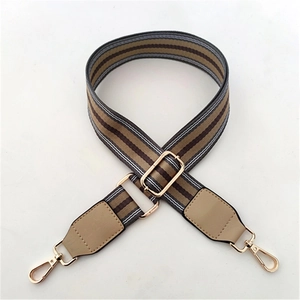 Adjustable striped bag strap featuring brown and white weaving with golden metal clips