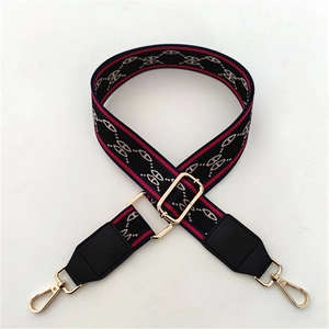 Detail of adjustable wide striped shoulder strap with gold metal buckles for crossbody bags