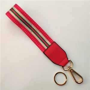 Detail of red nylon wrist strap with green stripes and golden metal lobster clasp