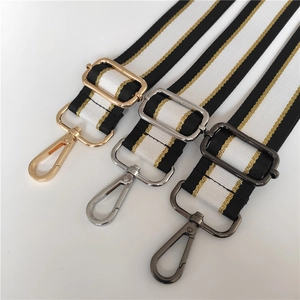 Detail view of adjustable wide shoulder straps with gold, silver, and black hardware buckles