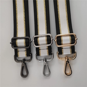 Detail of adjustable woven bag strap with black white stripes and gold metallic thread