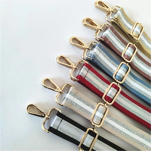 Close-up of adjustable woven bag straps in multiple colors with gold metal buckles