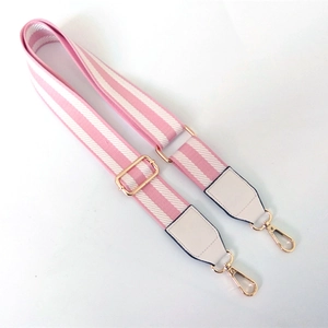 Detail of adjustable pink and white striped bag strap with gold metal hooks and leather ends