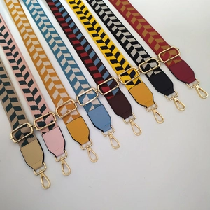 Close-up of adjustable woven shoulder straps with chevron patterns and gold hardware
