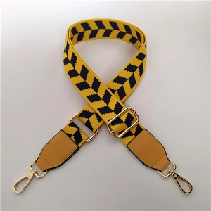 Close-up of adjustable yellow geometric pattern shoulder strap with gold metal hooks