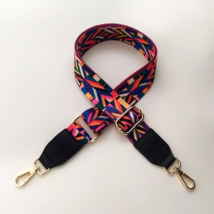 Detailed view of bohemian style colorful woven bag strap with golden metal hardware