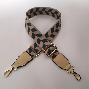 Detail of adjustable khaki herringbone strap with leather ends and metal lobster clasps