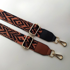 Close-up of geometric woven replacement straps with gold buckles and faux leather ends
