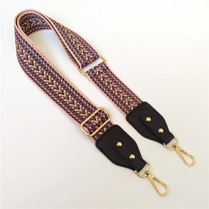 Detail der ethnischen Taschenriemen mit Webmuster in Pink und Grün sowie Goldbeschlägen