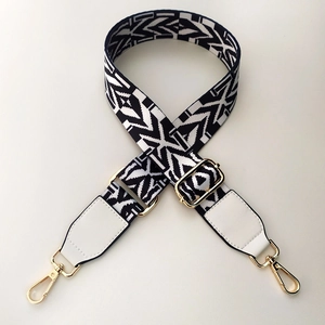 Close-up of black and white geometric ethnic strap with gold metal lobster clasps