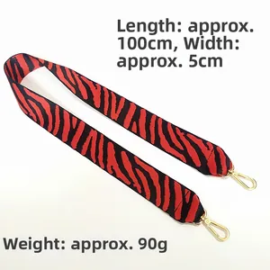 Détail de bandoulière large motif tigre rouge et noir avec crochet doré de 5cm