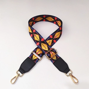 Close-up of ethnic patterned wide shoulder strap with geometric weave and gold hooks