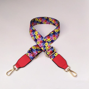 Detail of bohemian floral wide strap with red leather ends and gold-tone metal hooks