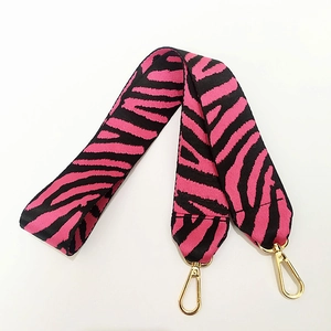 Détail de la bandoulière tissée à motif zèbre rose et noir avec fermoirs dorés