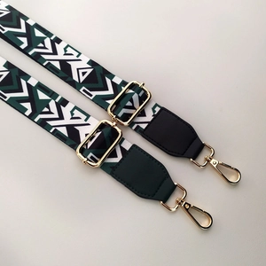 Detail of green ethnic pattern wide bag strap with gold lobster claw clasps and slider