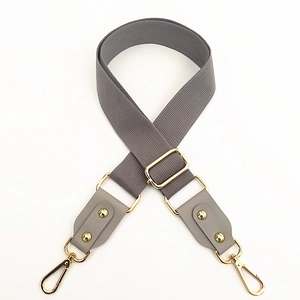 Detail of gray cotton woven adjustable shoulder strap with gold metal lobster clasps