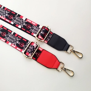 Detail of adjustable wide shoulder strap featuring red and black geometric ethnic patterns
