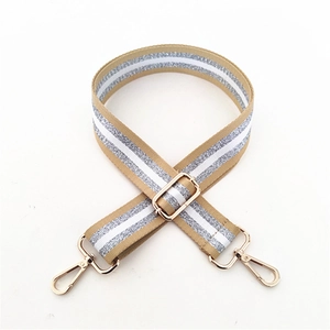 Detail of adjustable khaki bag strap with silver glitter stripes and gold metal lobster clasps