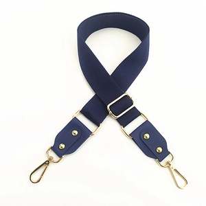 Close-up of wide navy cotton strap with gold hardware and adjustable buckle for bags