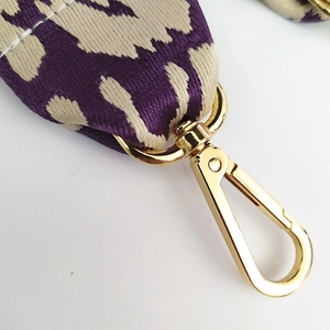 Macro shot of purple leopard woven strap with shiny gold lobster claw metal clasp
