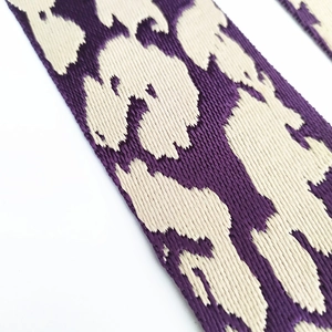 Detailed macro view of purple leopard jacquard pattern on high-quality wide bag strap