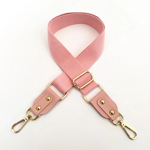 Close-up of pink cotton strap with adjustable gold metal buckle and leather ends