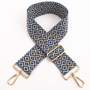Close-up of ethnic geometric embroidered bag strap with golden metal lobster clasps