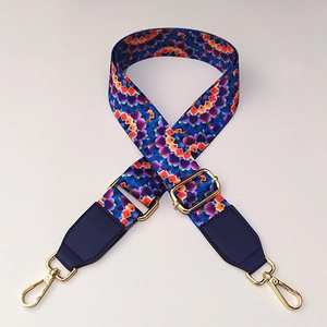Detail of adjustable colorful woven strap with blue leather ends and gold metal hooks